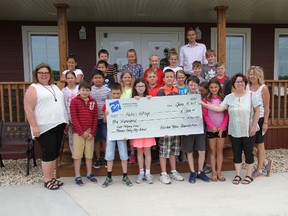 EMMS grade five class and Lynda Lambert-MacLean of MAF present cheque to Katie's Cottage. (THOMAS FRIESEN, Morden Times)