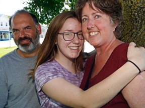 Luke Hendry/The Intelligencer
Double lung transplant Jacquie Morris of Frankford gets a hug from Emily Maracle, one of her three children, while with husband Todd Daley in Belleville. A month after her surgery, Morris is doing well and asking more people to register as organ donors.