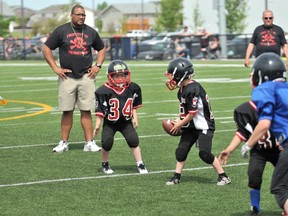 Gordon Anderson/Daily Herald Tribune
Atom Black quarterback Kaeden Biette (#19) tries to hand the ball off to Logan Boucher (#34) during the Atom Football Jamboree at CKC Field on Sunday afternoon. The Atom Black and Atom Blue clubs hosted the Peace River Pirates and the Sexsmith Clovers.