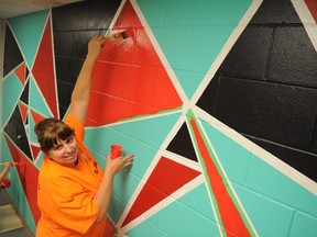Kim Mendonca, an employee at Cargill, works on a mural at the South London Neighbourhood Resource Centre. Volunteers taking part in the United Way’s Day of Caring brightened up a space used by the resource centre’s youth council. (Chris Montanini/Londoner)
