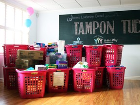 Hot pink bins filled with feminine hygiene products line the front of the Ten Seven Cafe & Lounge in Chatham on Tuesday. The bins were filled as a part of Chatham-Kent's second annual Tampon Tuesday, a campaign set to raise awareness to the inequity of access to these kinds of products for women in need. (FALLON HEWITT / THE DAILY NEWS)