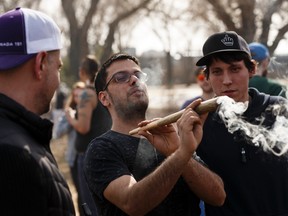 Revelers smoke a big joint during the 4/20 marijuana rally at the Alberta Legislature in Edmonton, on Friday, April 20, 2018. Photo by Ian Kucerak/Postmedia