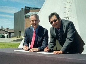 Cambrian College president Bill Best (left) and Ron Sarazin, chair of the Circle for Indigenous Education, sign the Indigenous education protocol at the college on Wednesday. (supplied photo)