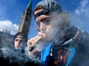 A man smokes a marijuana joint during the annual 4/20 celebration on Parliament Hill in Ottawa on Friday, April 20, 2018. The Canadian Press/Justin Tang