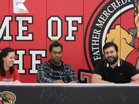 Lamar Goods (Centre) signs the papers at Father Patrick Mercredi in Fort Mcmurray on June 20, 2018 to join St. Thomas More school in the fall. Laura Beamish/Fortt McMurray Today/Postmedia Network