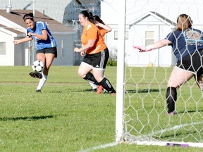 Dunrite Rubber Wolfpack forward Adriana Pacitto gets off a solid strike past a pair of Compass Brewing Growlers defenders as keeper Brittney Lemaire looks on during the first half of Thursday night’s TWSC contest at Roland Michener Secondary School. Lemaire was able to come up with the save on the play, but Pacitto did manage to score her TWSC-leading 10th goal of the season. It would be the Wolfpack’s lone goal in the contest, as they went on to drop a 3-1 decision to the Growlers.   THOMAS PERRY/THE DAILY PRESS