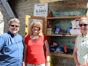 Jonathan Ludlow/The Intelligencer
A Blessing Box has been started at St. John's Anglican Church. The box is a place for people to anonymously pick up essential non-perishable items they might be unable to afford. From left, Reverend. Nancy Beale, Lynda Belknap, and Jane Schuell are all involved with its upkeep and replenishment.