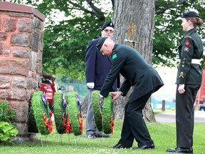 Lt.-Col. Lance Knox, commanding officer of 49th Field Regiment, presents a wreath accompanied by Warrant Officer Cassandra Breckenridge, of 2310 Royal Canadian Army Cadets, as emcee Pierre Breckenridge watches during a Korean War memorial service at Sault Ste. Marie Canal National Historic Site on Friday.