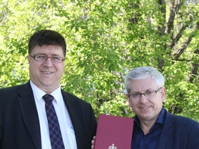 MP Charlie Angus (NDP – Timmins-James Bay), right, presents Dr. Anthony Kos with a folded Canadian flag that previously flew on the Peace Tower in Ottawa. Kos said he plans the fly the flag at the top of the Hollinger No. 26 shaft headframe during the Stars and Thunder festival leading up to Canada Day. Kos, who is the owner of the Hollinger Golf Club, said he also plans to have it flying on Aug. 9 which will be the 96th anniversary of the start-up of Timmins’ oldest golf course.