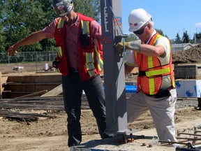 City of Spruce Grove Mayor Stuart Houston sets the first column in place for the new protective services building.