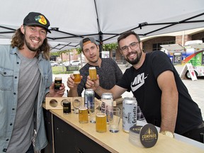 Peter Lazar (left), creative director for the True North Beer Festival, raises a glass with Erwin Bocianski (centre)  of Lake on the Mountain Brewing Co. from Picton, and Matthew Thompson of  Compass Brewing from Timmins on Saturday at downtown Harmony Square. (Brian Thompson/The Expositor)