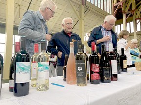 A group of  gentlemen check out some of the wine selections at Uncork Canada at Crystal Palace in Picton on Saturday.