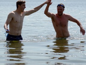 Jonathan Ludlow/The Intelligencer
Timothy Boyle and Aaron McKinney high-five as they complete the Roblin Lake Swim. The Roblin Lake Swim for Strong Kids took place Tuesday in Ameliasburgh. Participants swam or paddled three kilometres across Roblin Lake and back to raise funds for YMCA Strong Kids Campaign, a campaign designed to raise funds and resources to eliminate barriers preventing children from participating in YMCA programs.