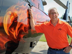 Paul Spring, owner and president of Phoenix Heli-Flight, poses with one of his helicopters south of Fort McMurray, Alta. on Thursday June 29, 2017. Vince Mcdermott/Fort McMurray Today/Postmedia Network