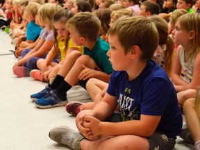 Atticus Grive-Thyssen, right, in kindergarten, sits quietly during the final year-end assembly at Sparta Public School, slated to close this summer and reopen in the fall as a French Immersion school. Old parents, teachers, and past school graduates — including MP Karen Vecchio — were at the assembly, many of them still upset about the school closing. (Louis Pin/Times-Journal)