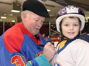 Former New York Islanders goalie Billy Smith, shown here signing an autograph for young fan Albert Plante in 2006, will be in Timmins for the third-annual Timmins Rock 4-Person Scramble at the Hollinger Golf Club on Saturday, Aug. 18.  POSTMEDIA FILE PHOTO