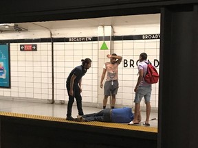 Three men look on after rescuing a blind man that had fallen onto the subway tracks at Broadview Station in Toronto on Thursday, June 28, 2018. A Toronto transit rider credited with saving a man who fell onto the subway tracks said he couldn't have done it without the help of two others who jumped in with him. THE CANADIAN PRESS/HO - Julie Caniglia
