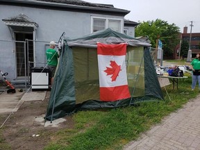 Volunteers from Habitat for Humanity set up a tent to shelter from the rain at their Open House Saturday. SUBMITTED PHOTO