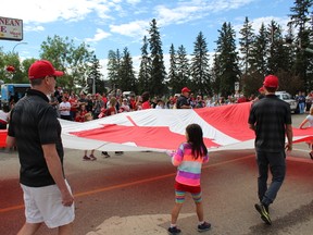 People hold a giant Canadian Flag at the Canada Day Parade in Fort McMurray, Alta. on Sunday, July 1, 2018. Vincent McDermott/Fort McMurray Today/Postmedia Network