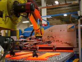 Robot 2 picks up 900 degree slabs of cut steel before they are hot pressed at quenched at Formet in St. Thomas. (MIKE HENSEN/The London Free Press)