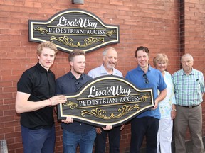 The family of the late Lisa Dalpe gather around signs about to be erected marking the Lisa's Way Pedestrian Access at a ceremony attended by about 30 people on June 15. In the photo are sons Zac (left) and Ben, Lisa's husband Paul, son Phil, Brant Coun. Shirley Simons and Brant Mayor Ron Eddy. (Photo courtesy of Ayr News)