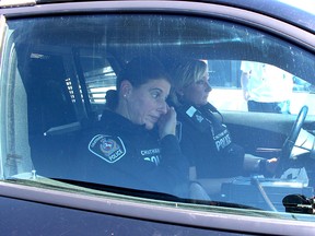 Chatham-Kent Police Service constables Renee Cowell, front, and Lynette Hodder, feel the heat while spending 15 minutes in a police cruiser, in full uniform, as the temperature soared to 44 C. The officers were taking part in an event organized by Pet and Wildlife Rescue in Chatham, Ont. on Friday July 6, 2018, to highlight the dangers of leaving pets in hot vehicles. Ellwood Shreve/Chatham Daily News/Postmedia Network