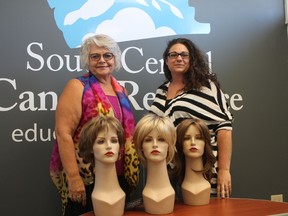 Clinical coordinator Deb Thiessen and administrative coordinator Tracy Peters showcase a few of the wigs that can be named during the Name That Wig auction.