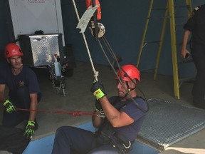 St. Thomas firefighter Luke Intven is strapped into a harness connected to a series of ropes that lower him into a hole in the ground during confined space training Thursday afternoon. The department is currently looking to hire two temporary recruit firefighters that will eventually fill vacancies due to pending retirements within the next six months. (Laura Broadley/Times-Journal)