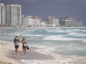 A couple walks along Marlin beach in Cancun, February 1, 2011. (Reuters/Gerardo Garcia)