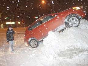 FILE PHOTO: A vehicle sits high on a snowbank in Winnipeg on Jan. 23, 2011. (QMI Agency)