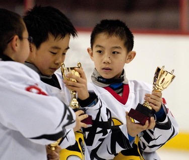 OTTAWA, Ont. (03/01/11)-- Beijing Little Wolf players inspect their trophies after winning the Atom Hosue A championship game against the Almonte Thunder on Monday in Scotiabank Place during the Bell Capital Cup. Beijing Little Wolf beat Almonte Thunder with a score of 5-1. Photo by Hadas Parush.