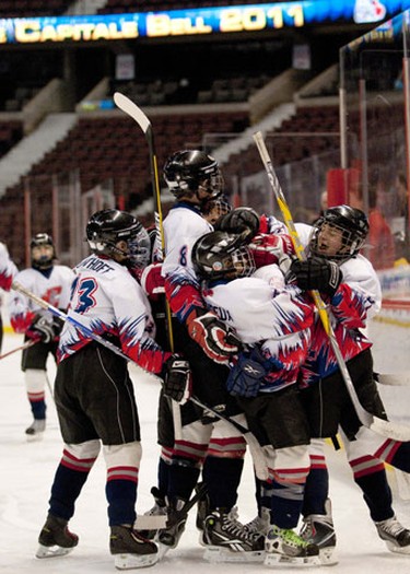 OTTAWA, Ont. (03/01/11)-- South End Comets hug each other and cheer after scoring the first goal during the first period of the Peewee House A championship game against the West End Dynamite on Monday at Scotiabank Place during the Bell Capital Cup. The Comets beat Dynamite with a score of 1-0. Photo by Hadas Parush.