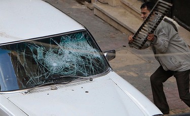 An Egyptian Christian hits a car during clashes with Egyptian riot police in front of a Coptic Orthodox church in Alexandria, 230 km (140 miles) north of Cairo, on Jan. 1, 2011. (REUTERS)