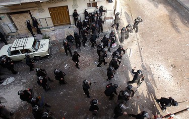Egyptian riot police throw stones during clashes outside a Coptic Orthodox church in Alexandria, 230 km (140 miles) north of Cairo, on Jan. 1, 2011. (REUTERS)