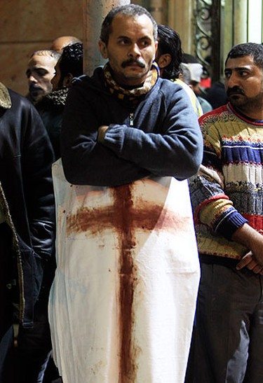 An Egyptian Christian hugs a white cloth smeared with blood from victims of a car bombing outside the Coptic Orthodox church in Alexandria, 230 km (140 miles) north of Cairo, on Jan. 1, 2011. (REUTERS)