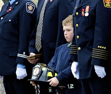 Connor Jones, 8, holds the hat of his grandfather, Lieutenant Richard Gietz, during the Canadian Fallen Firefighters Memorial Ceremony at Parliament Hill in Ottawa September 12, 2010. September 12,2010 (Errol McGihon/The Ottawa Sun)