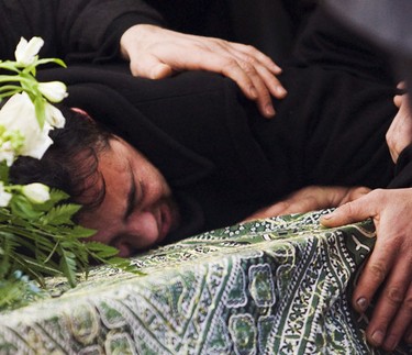 Ali Ghiasi, the father of murder victim,Yazdan Ghiasi, drapes his body over his son's casket during the funeral service at the Ottawa Mosque Thursday, December 9, 2010.  (Darren Brown/Ottawa Sun)