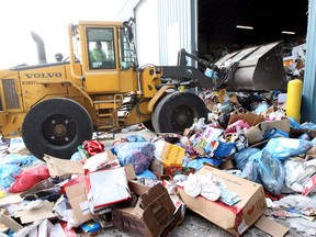 Crews push recyclables on to the tipping floor at the Materials Recovery Facility, at the Edmonton Waste Management Centre, 13111 Meridian St., Dec. 29, 2010. The facility recycles between 180 and 200 tonnes of material a day, a number that can double after Christmas. (DAVID BLOOM/EDMONTON SUN)