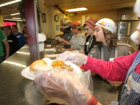 Siloam Mission volunteers dish out meals to the homeless at Christmas. The best part of the Christmas season, writes Floyd Perras, is the sense that anything is possible. (MARCEL CRETAIN/Winnipeg Sun file photo)