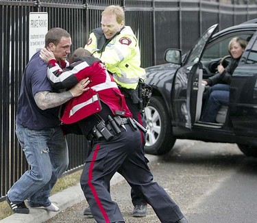 As victim Kim Ferner watches from her Lexus SUV, police struggle to control a man who tried to carjack her in Calgary, Wednesday, March 24.  LYLE ASPINALL/QMI AGENCY