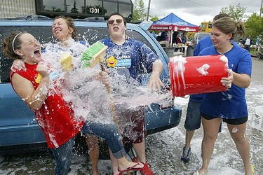 Girls react while being showered with a pail of water during a Cystic Fibrosis fundraising car wash in Winnipeg, June 12, 2010. Brian Donogh/QMI Agency