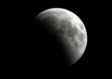 The Moon is engulfed in the Earth's shadow as it nears the peak of a rare winter solstice total lunar eclipse as viewed through a telescope from Palm Beach Gardens, Florida December 21, 2010. REUTERS/Doug Murray