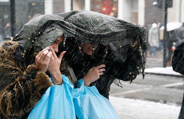 Shoppers cover their heads as the walk along Oxford Street, in central London on Dec. 18, 2010. Fresh snow brought much of Britain to a standstill on Saturday, on what is traditionally the busiest weekend for shopping and travel in the run-up to Christmas.   (REUTERS)