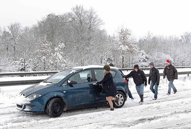 People push-start a car on the A3 near Guildford, in southern England on Dec. 18, 2010. Fresh snow brought much of Britain to a standstill on Saturday, on what is traditionally the busiest weekend for shopping and travel in the run-up to Christmas. (REUTERS)