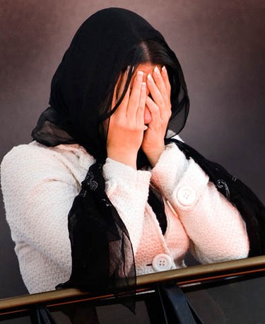 A woman covers her face as friends and family grieve for murder victim, Yazdan Ghiasi, during his funeral service at the Ottawa Mosque Thursday, December 9, 2010.  (Darren Brown/Ottawa Sun)