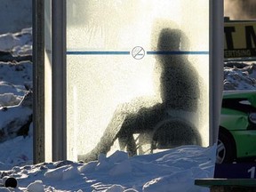 A Winnipegger waits for a bus in a frosty bus shelter in Winnipeg Dec. 13, 2010. The wind chill that morning made the air feel like -35 C.  (BRIAN DONOGH/Winnipeg Sun)