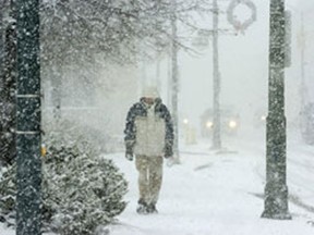 A pedestrian walks through a snow storm on York Street at Wellington Street in London on Sunday December 5, 2010.
MORRIS LAMONT/ QMI AGENCY