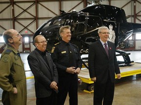 Winnipeg Mayor Sam Katz (second from left) and Manitoba Premier Greg Selinger (right) share a light moment prior to the unveiling of the new Winnipeg Police Service Eurocopter EC120B helicopter at 17 Wing in 2010. (BRIAN DONOGH/Winnipeg Sun)