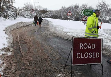 People walk down the A57 road which has been closed to vehicles for two days near Worksop, northern England on Thursday. Around 200 people were stranded on the road overnight and had to be rescued by mountain rescue crews after heavy snowfall, local media reported. (REUTERS/Nigel Roddis)