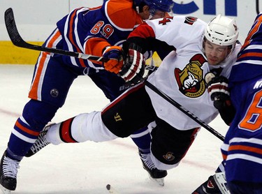 Ottawa Senators' Chris Phillips (4) is checked by Edmonton Oilers' Sam Gagner (89) during the third period of NHL action at Scotiabank Place Monday, November 29, 2010. Oilers won 4-1. (Darren Brown/Ottawa Sun)